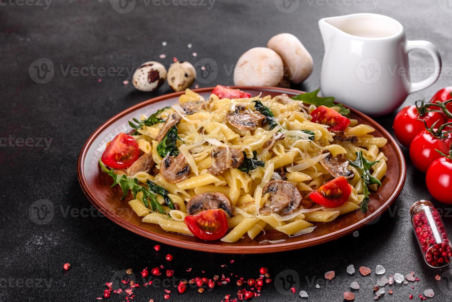 macarrão com cogumelos, queijo, espinafre, rukkola e tomate cereja foto