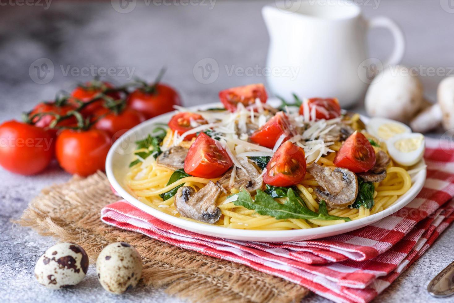 espaguete com cogumelos, queijo, espinafre, rukkola e tomate cereja foto