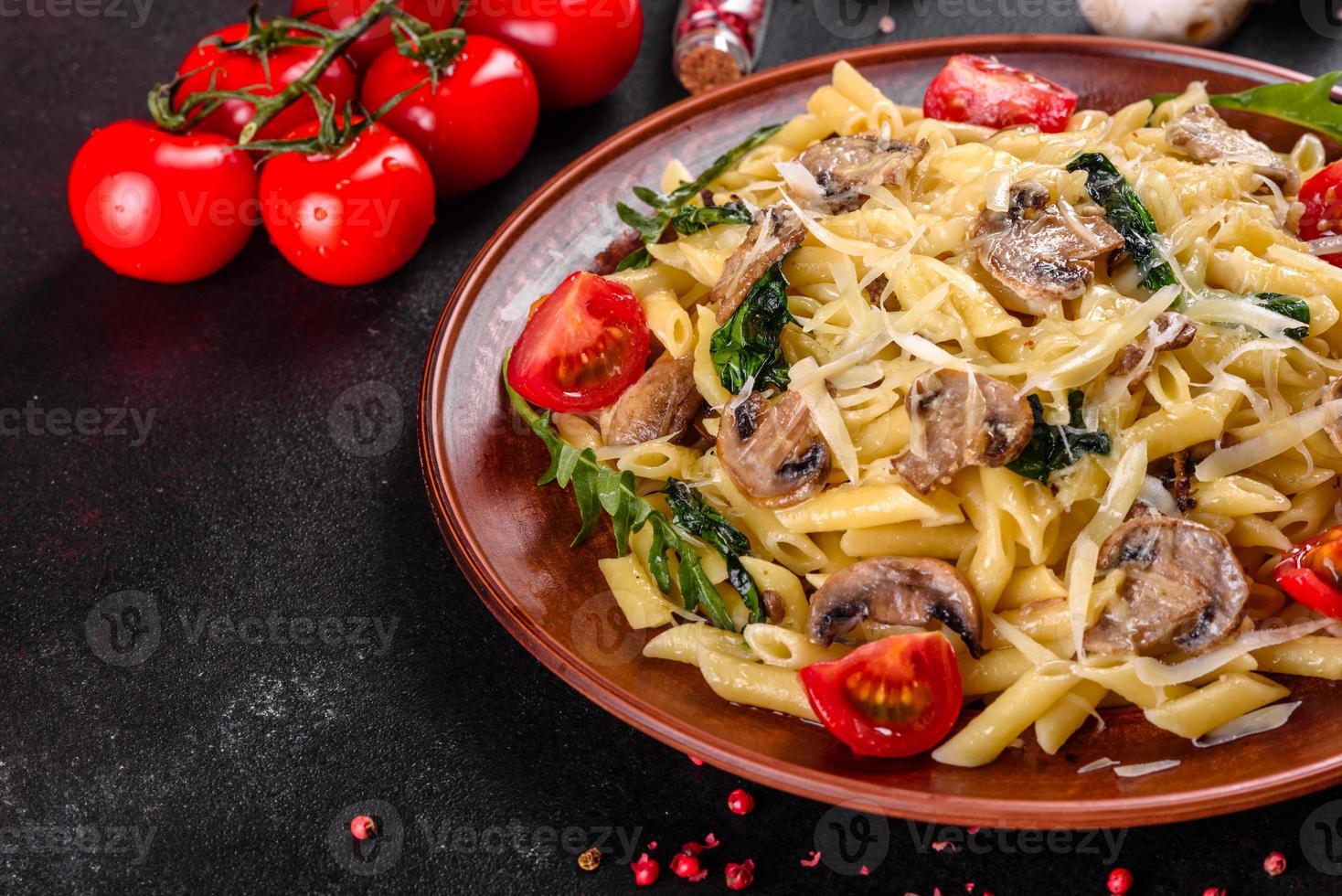 macarrão com cogumelos, queijo, espinafre, rukkola e tomate cereja foto