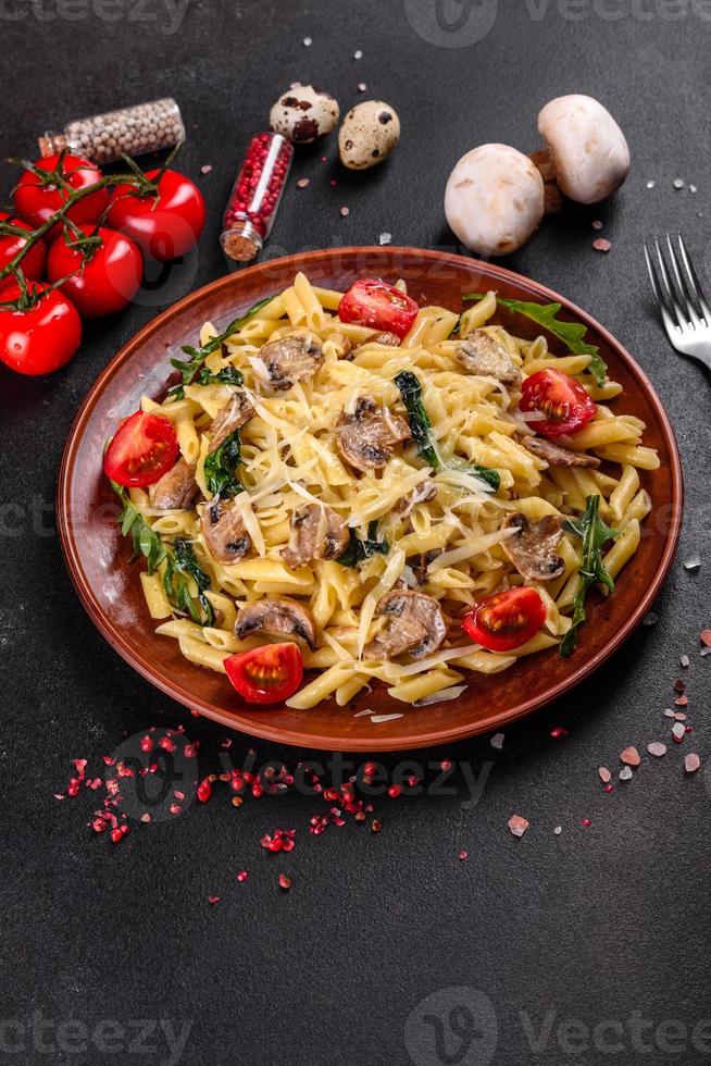 macarrão com cogumelos, queijo, espinafre, rukkola e tomate cereja foto