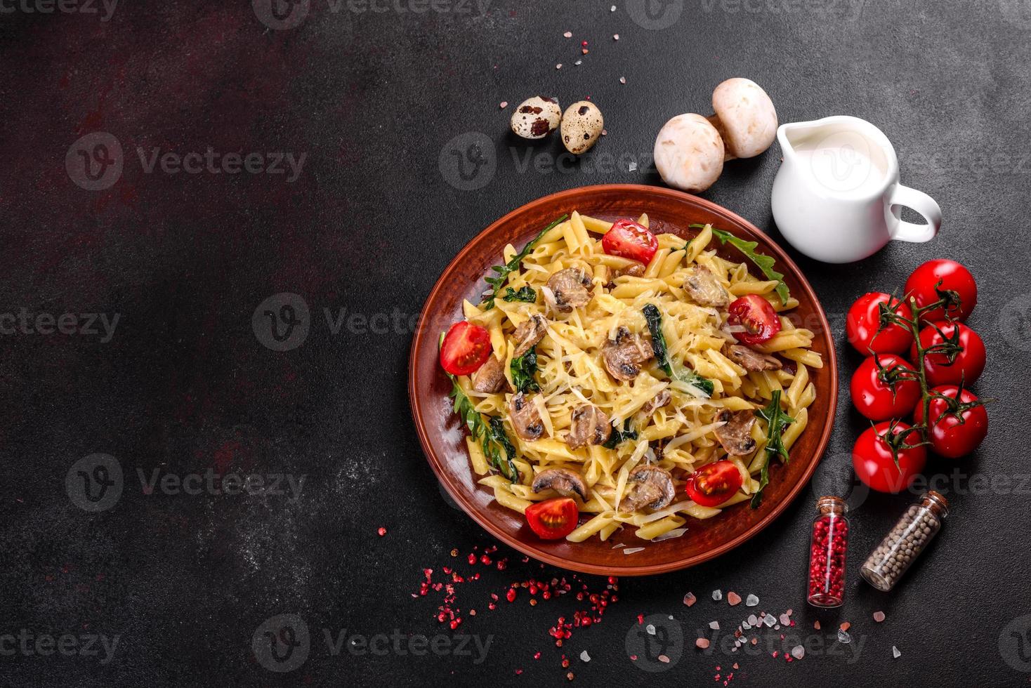 macarrão com cogumelos, queijo, espinafre, rukkola e tomate cereja foto