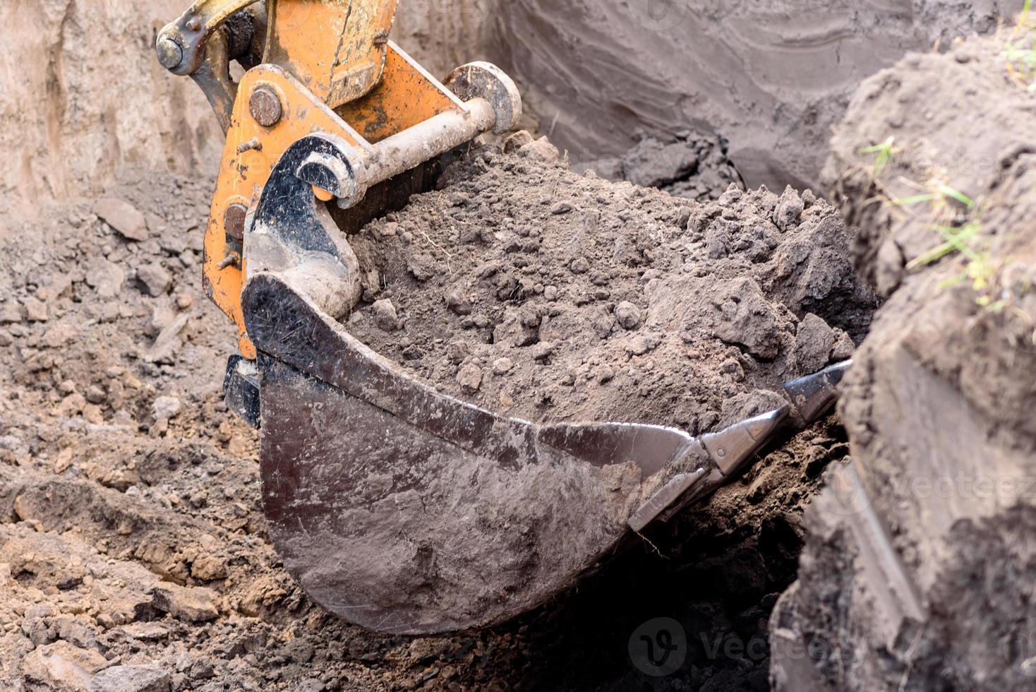 a escavadeira moderna realiza trabalhos de escavação no canteiro de obras foto