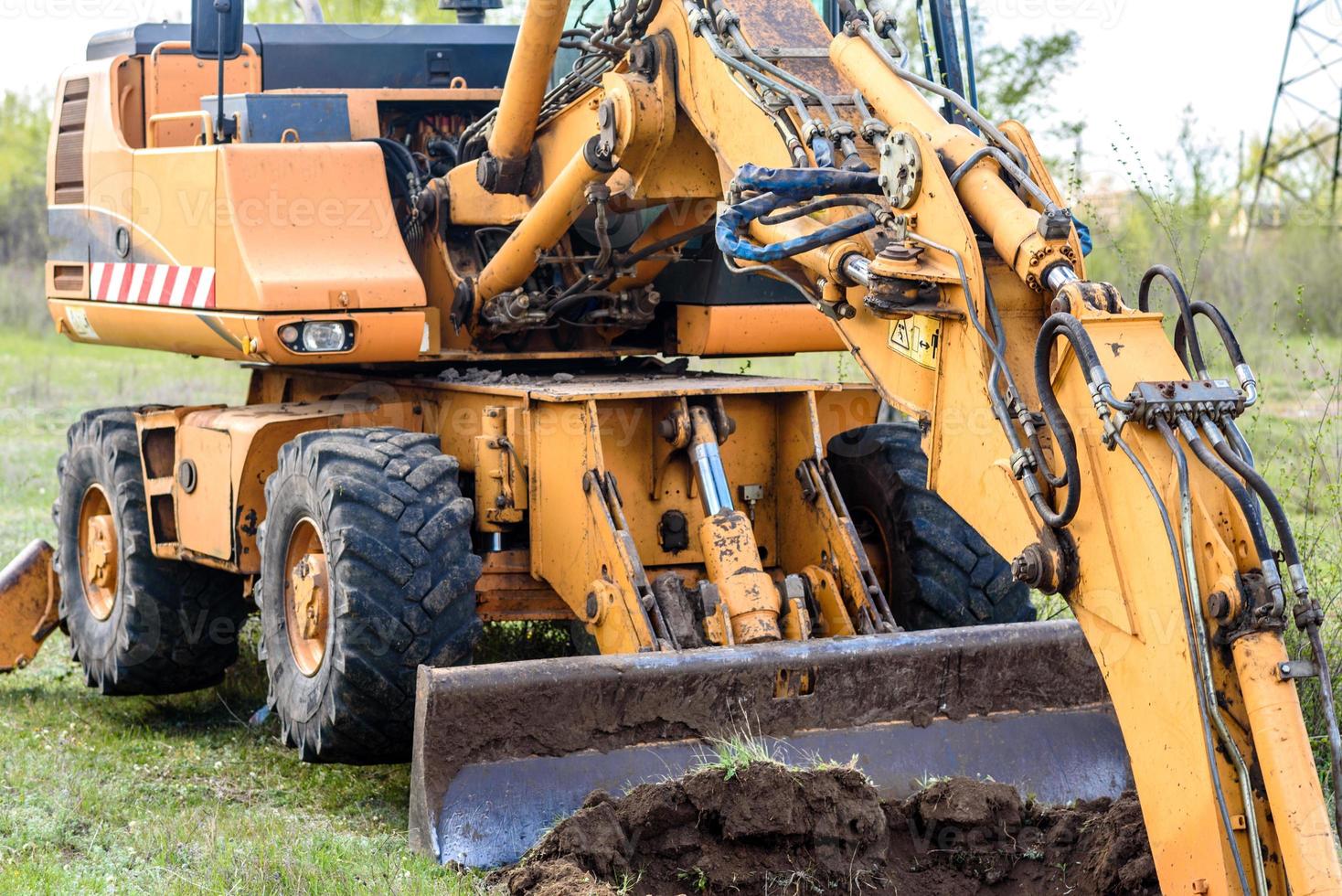 a escavadeira moderna realiza trabalhos de escavação no canteiro de obras foto