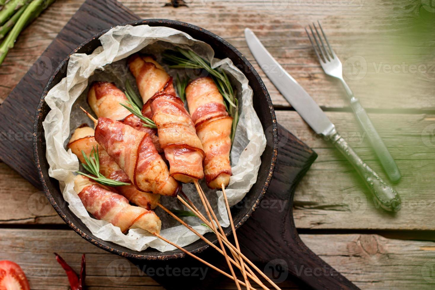 rolo com bacon e frango picado em um guisado com aspargos frescos foto