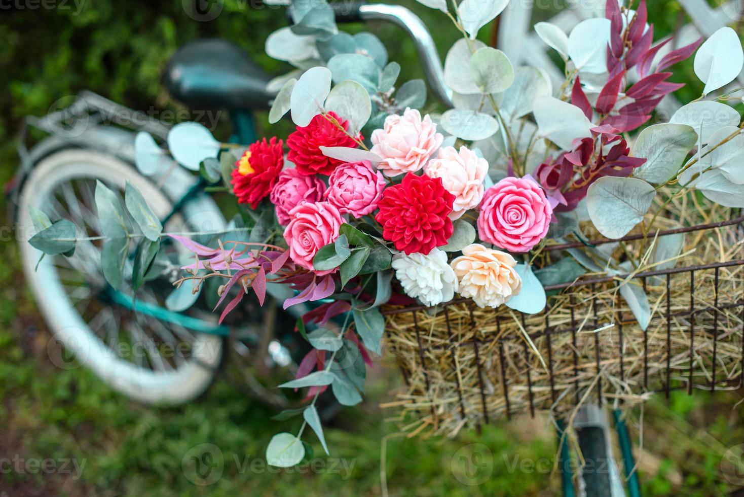 bela bicicleta com flores em uma cesta fica em uma avenida foto