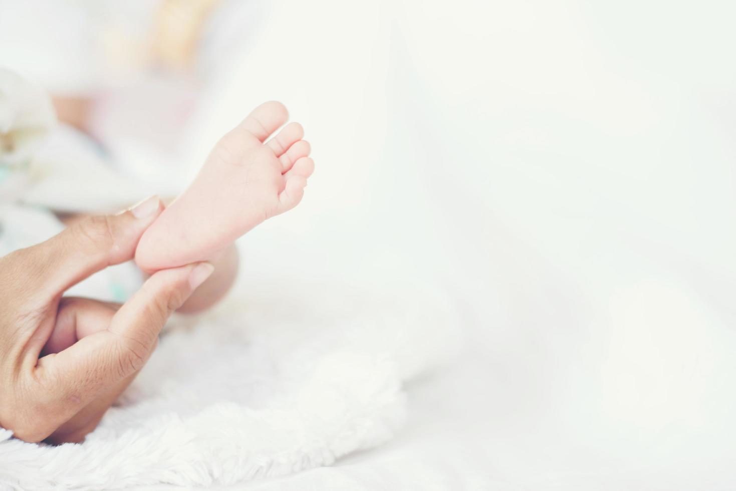pés do bebê newbron nas mãos da mãe. foto