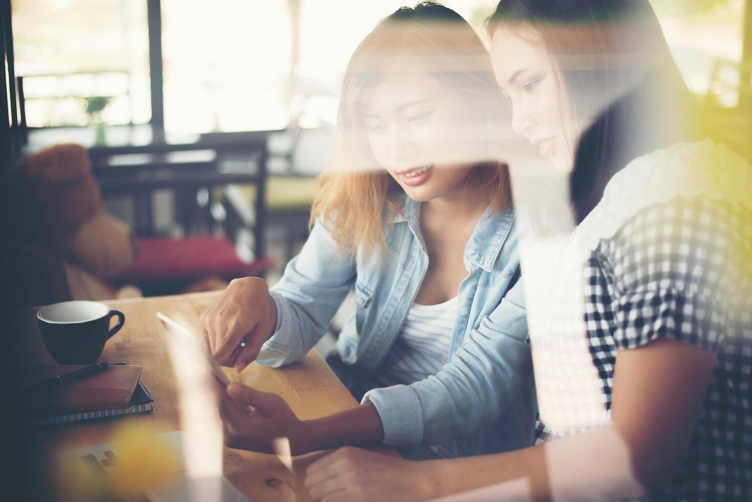 duas belas mulheres conversando em uma cafeteria foto