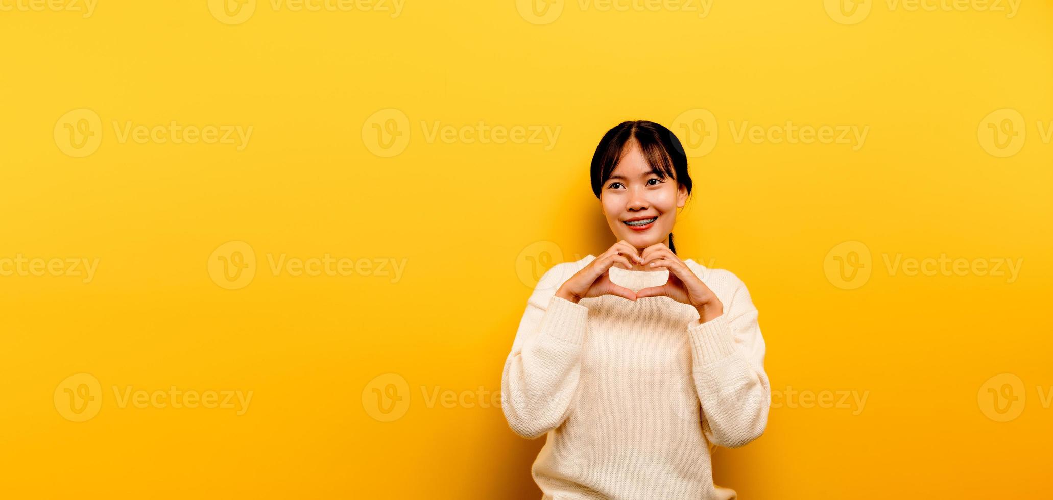 menina asiática linda com um vestido branco casual sobre um amarelo foto