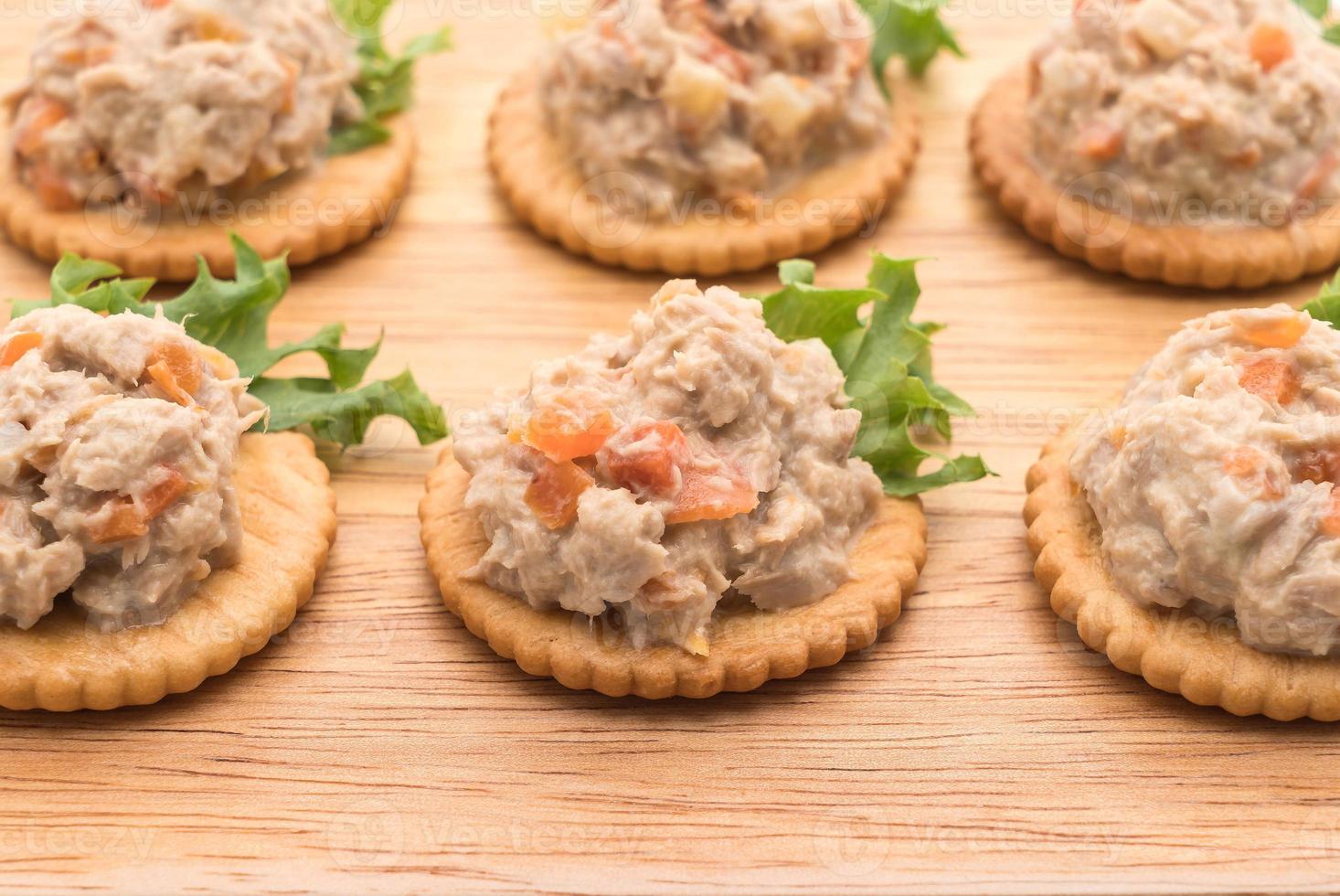 salada de atum com bolacha na tábua de madeira foto