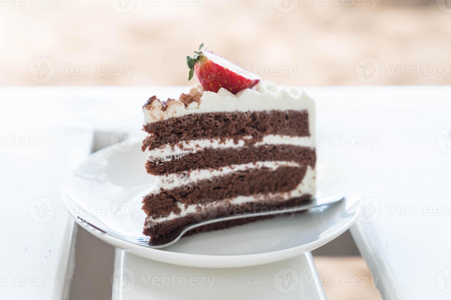 Bolo de baunilha e chocolate com morango no café foto