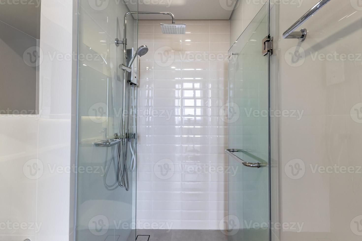 box amplo e porta de vidro no banheiro, sala de ladrilhos brancos foto