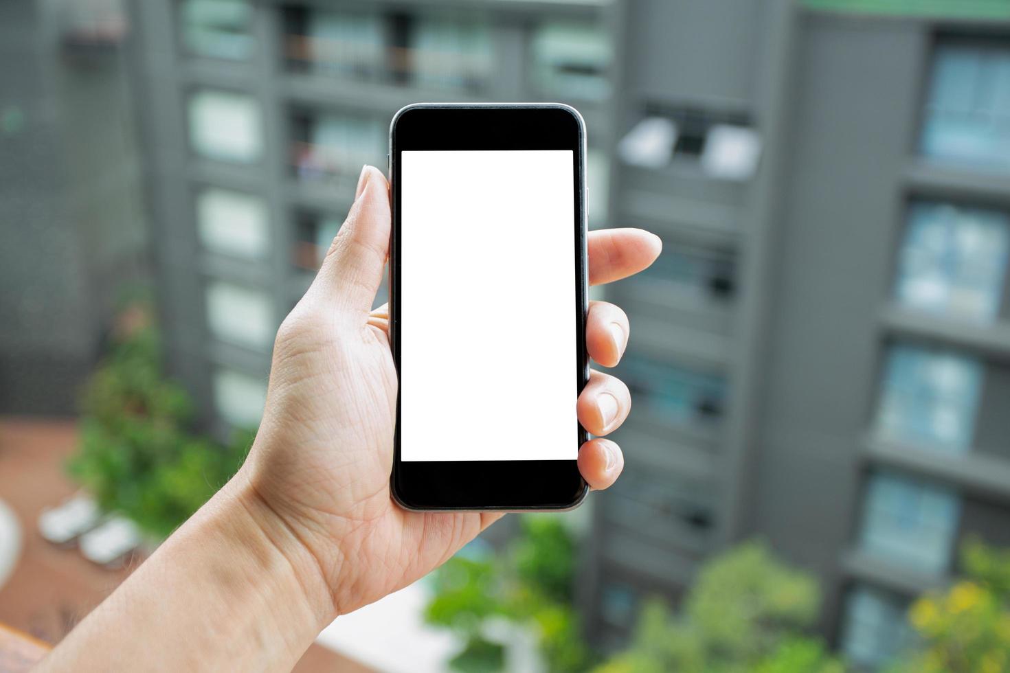 imagem de maquete da mão do homem segurando o smartphone com tela branca em branco. foto