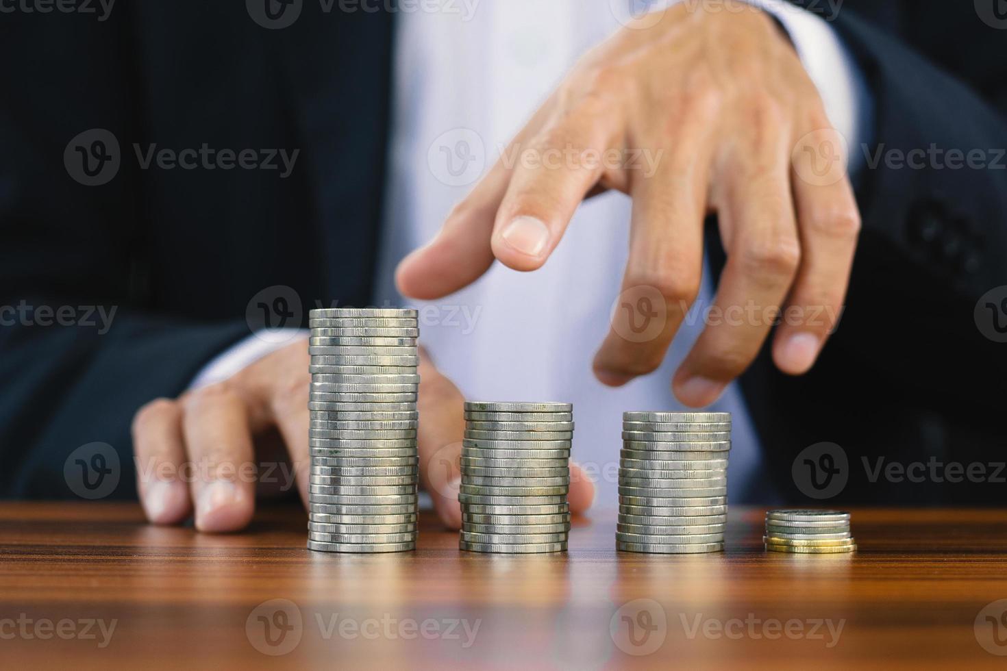 mão contando a pilha de moedas na mesa de madeira foto