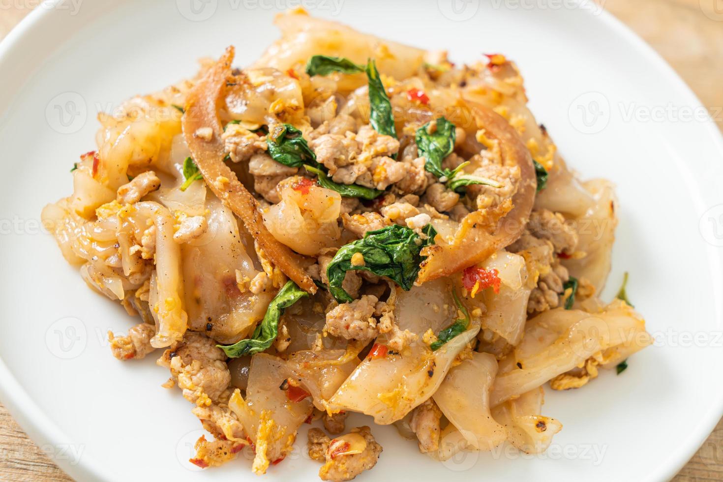 macarrão frito com frango picado e manjericão foto