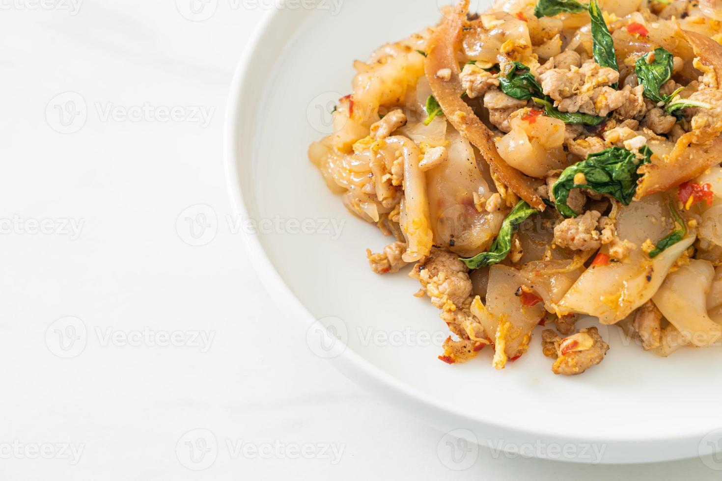 macarrão frito com frango picado e manjericão foto