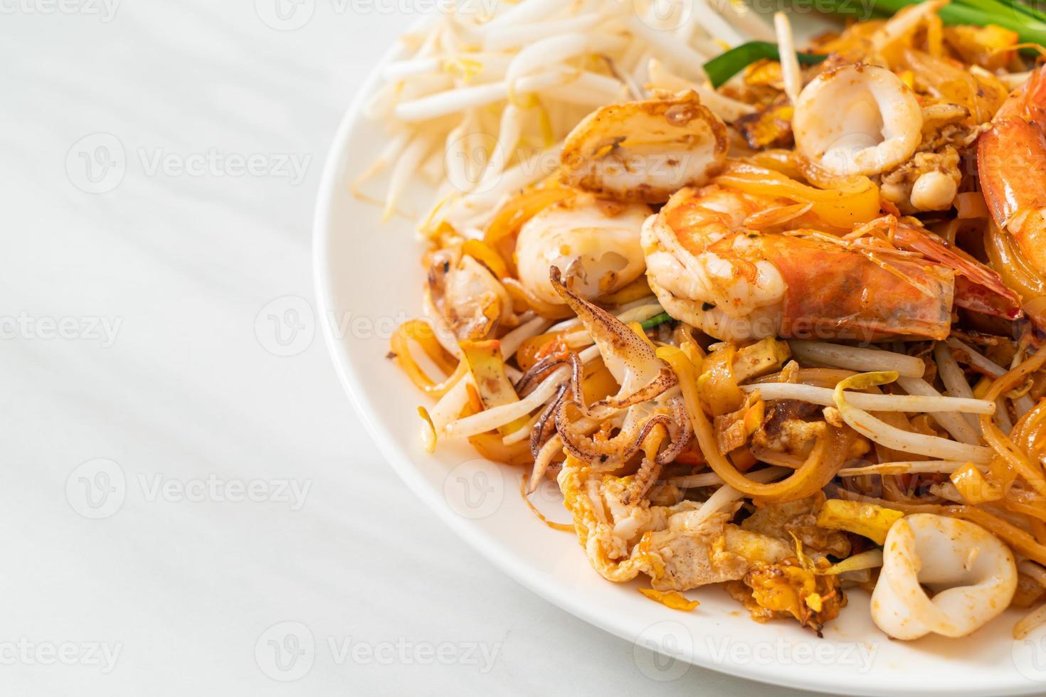 frutos do mar pad thai - misture macarrão frito com camarão, lula ou polvo foto