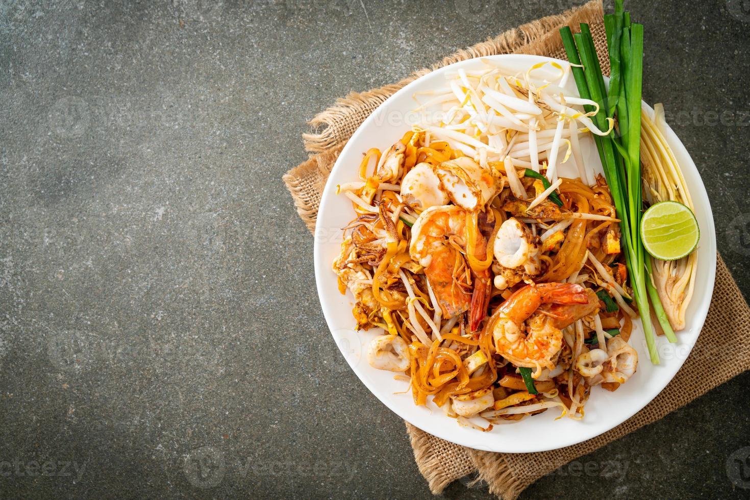 frutos do mar pad thai - misture macarrão frito com camarão, lula ou polvo foto