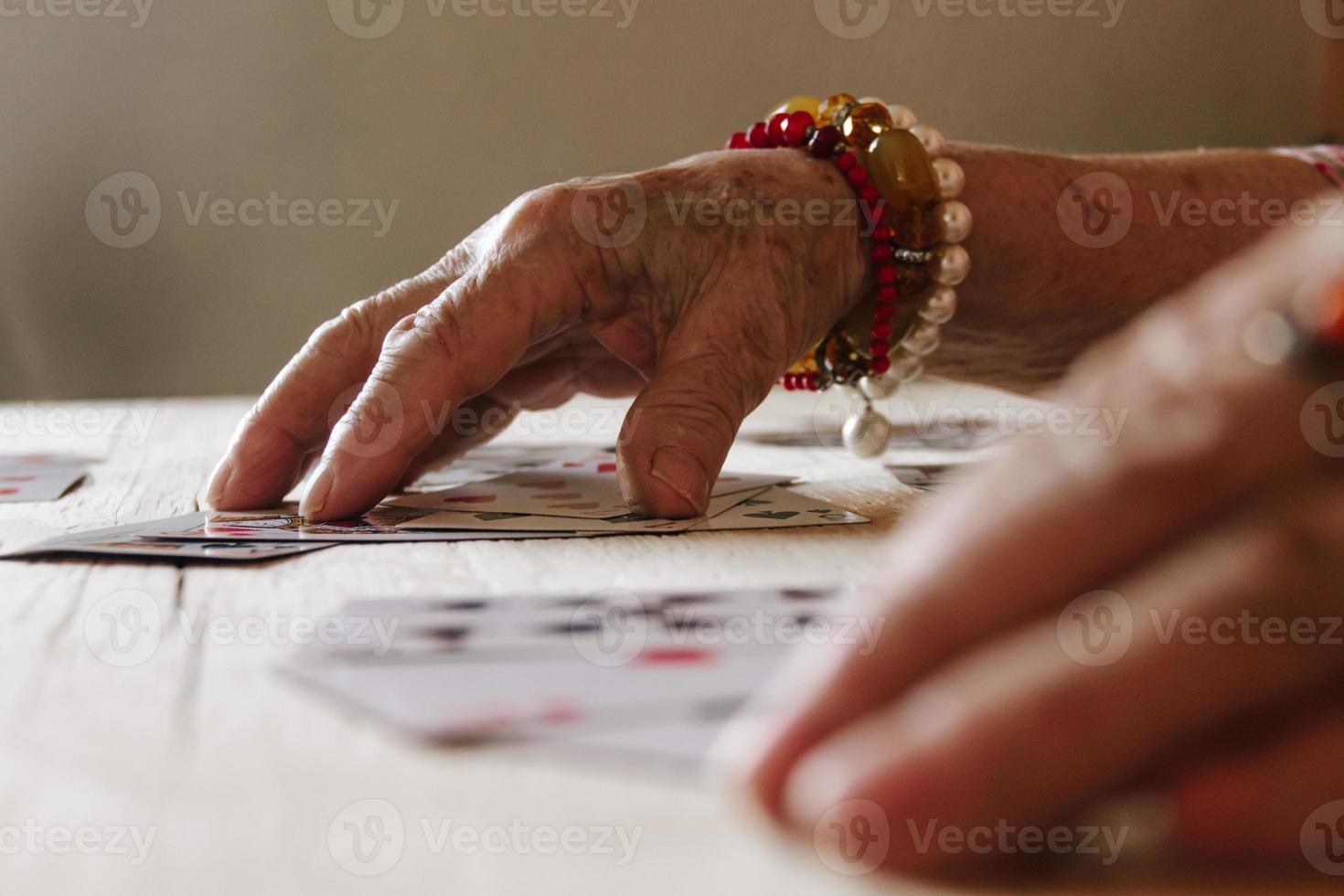 leitura de cartas de adivinhação, magia da avó, leitura da sorte, mãos de mulheres foto