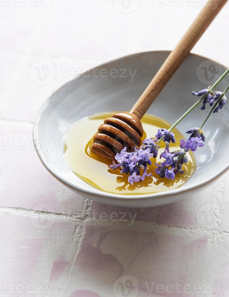 tigela com mel e flores frescas de lavanda foto