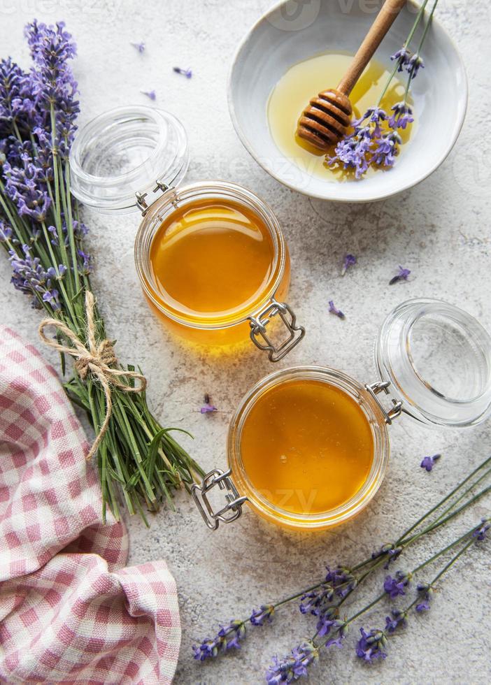 potes com mel e flores frescas de lavanda foto