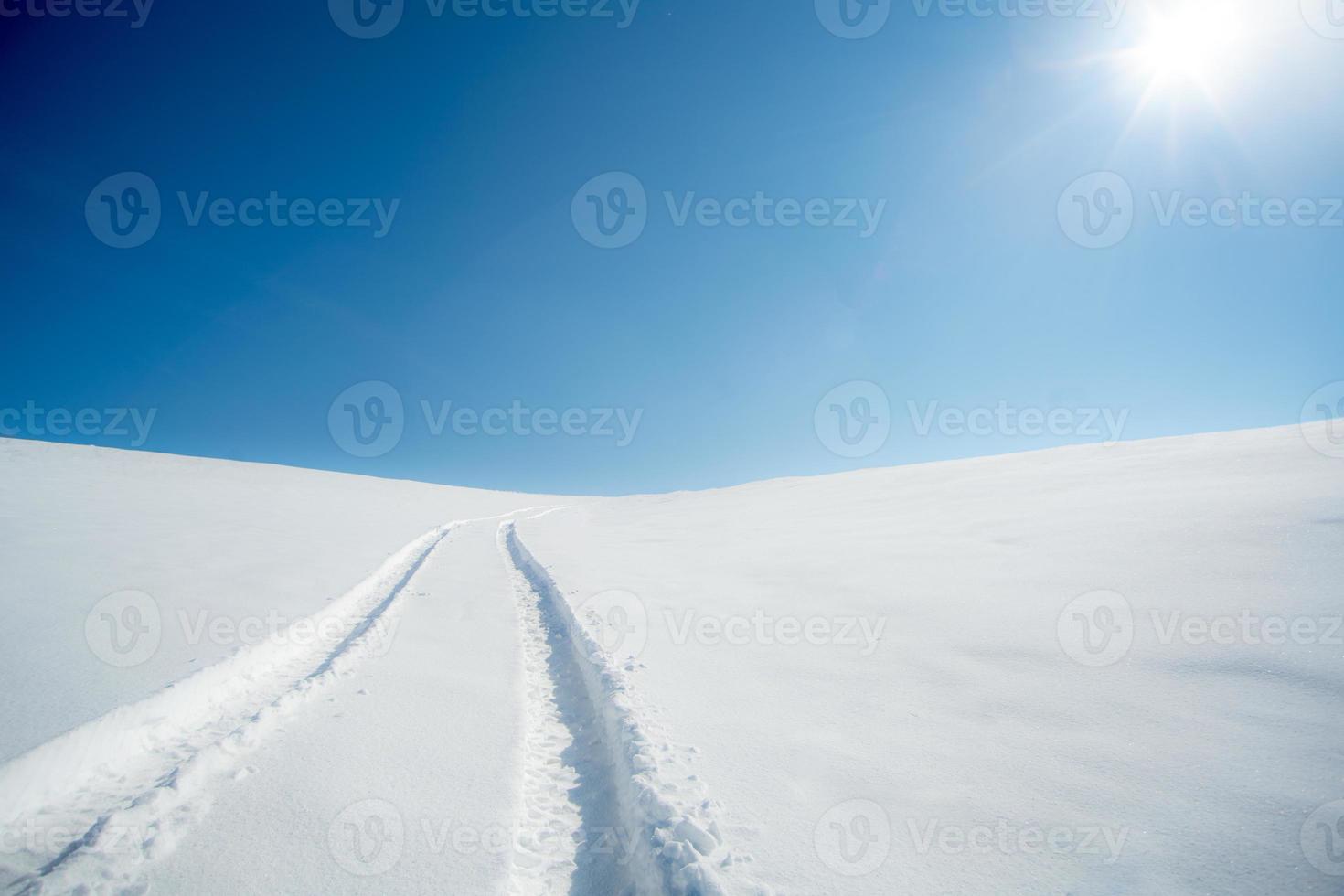 bela vista de um caminho de neve em um dia ensolarado foto