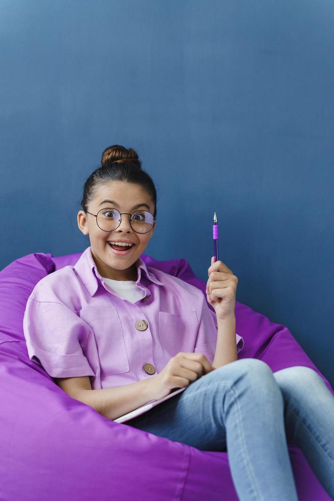 adolescente alegre e positiva com um sorriso tem uma ótima ideia foto