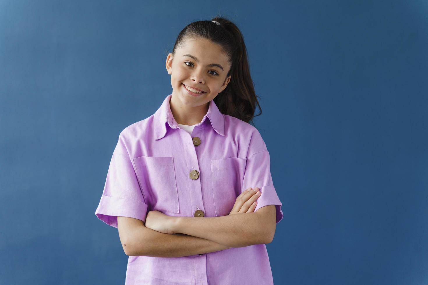 menina atraente e fofa cruzou os braços sorrindo lindamente foto