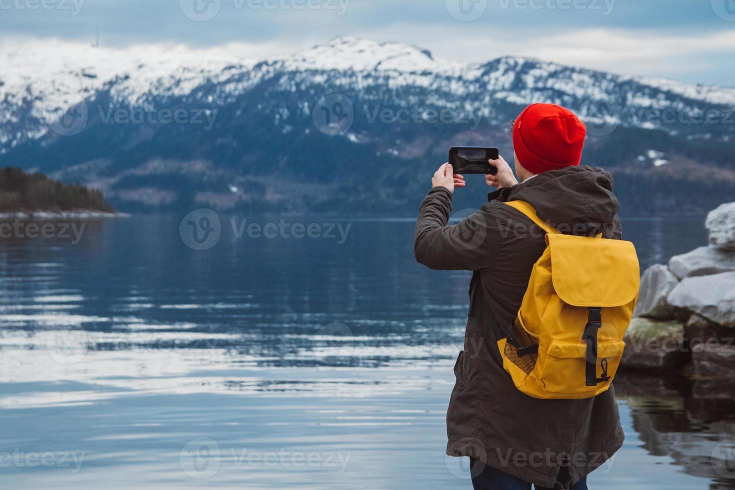 Homem viajante tirando foto com smartphone nas montanhas