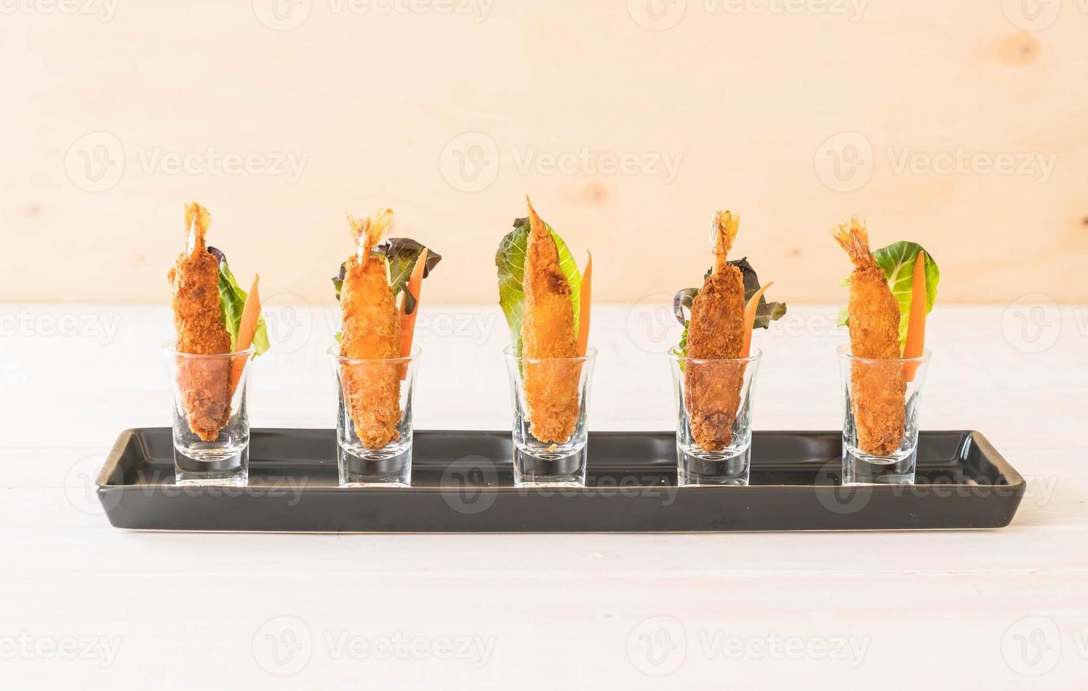 Camarões fritos em massa no prato branco foto