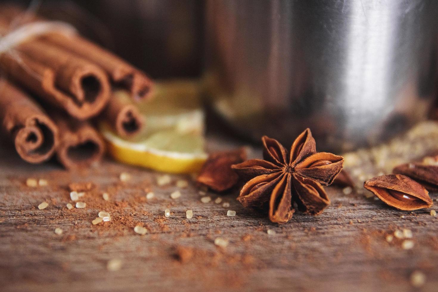 espécies perfumadas com canela, limão em um fundo de madeira foto