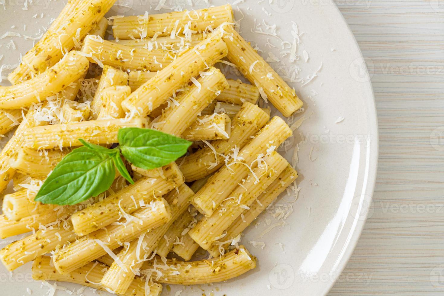 macarrão pesto rigatoni com queijo parmesão - comida italiana e comida vegetariana foto