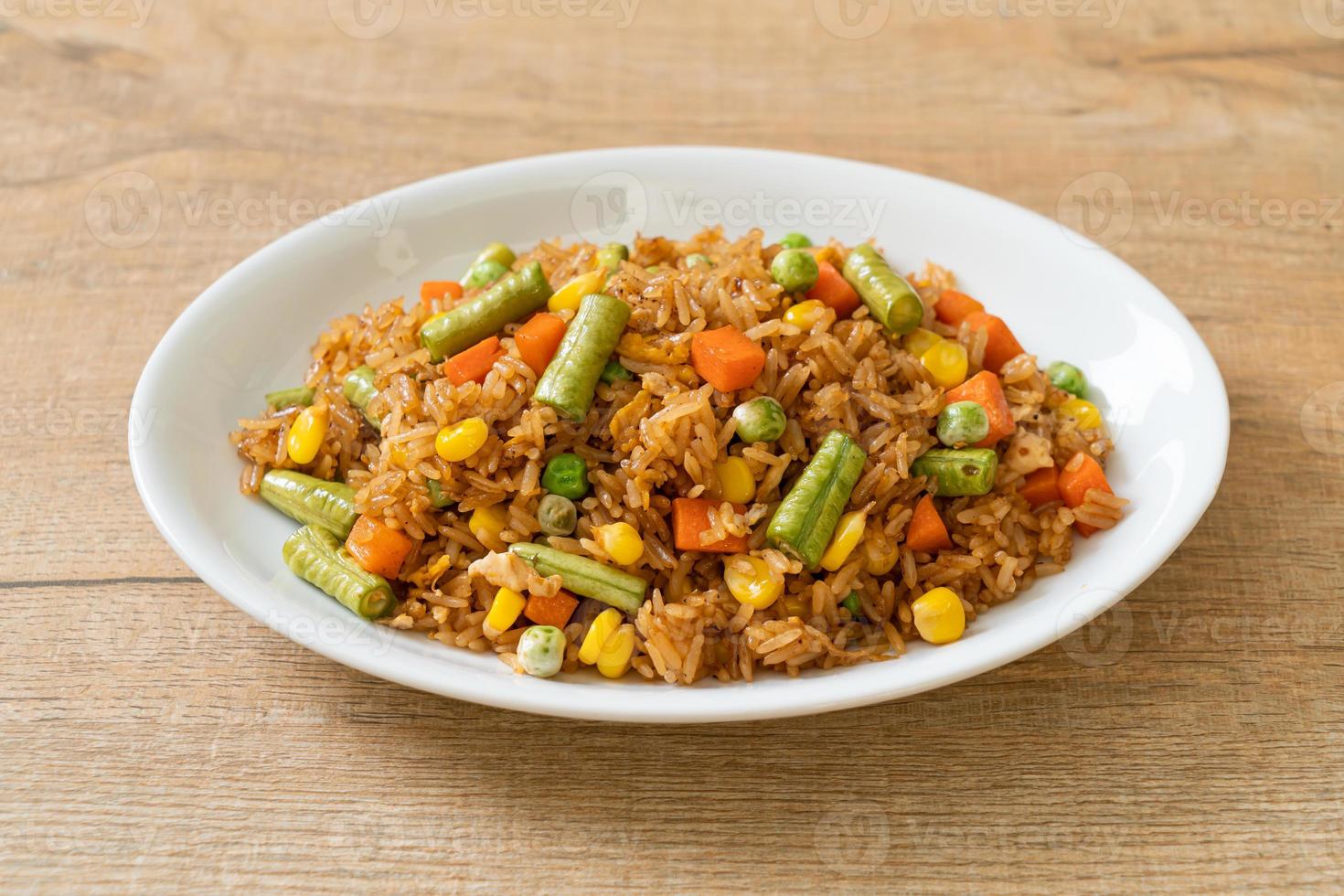 arroz frito com ervilhas, cenoura e milho - estilo de comida vegetariana e saudável foto