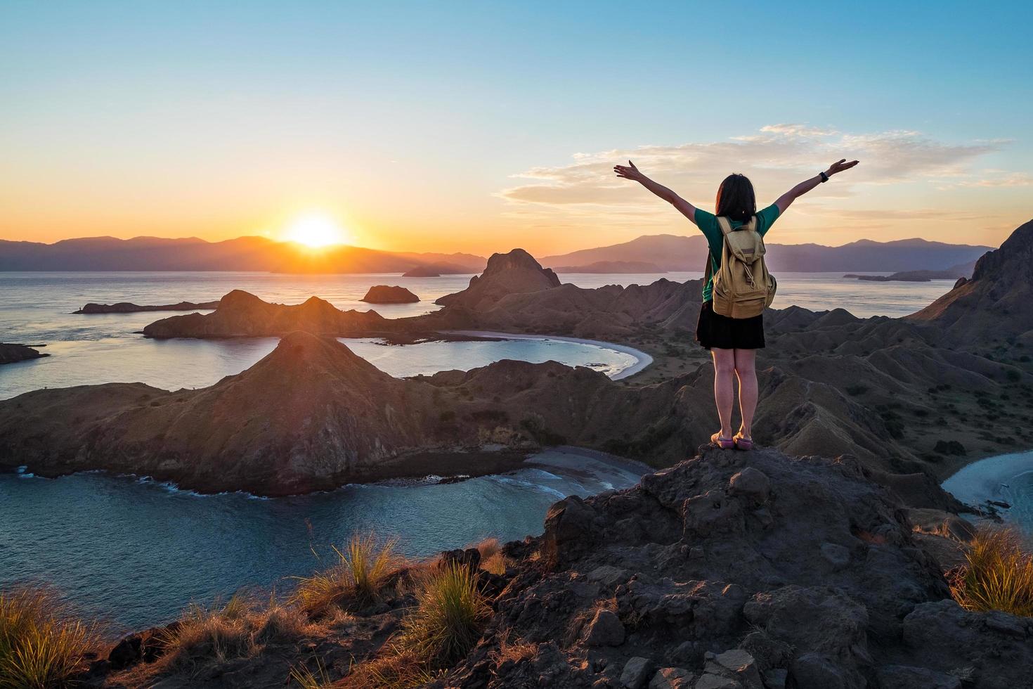 uma mulher no pico da ilha padar foto