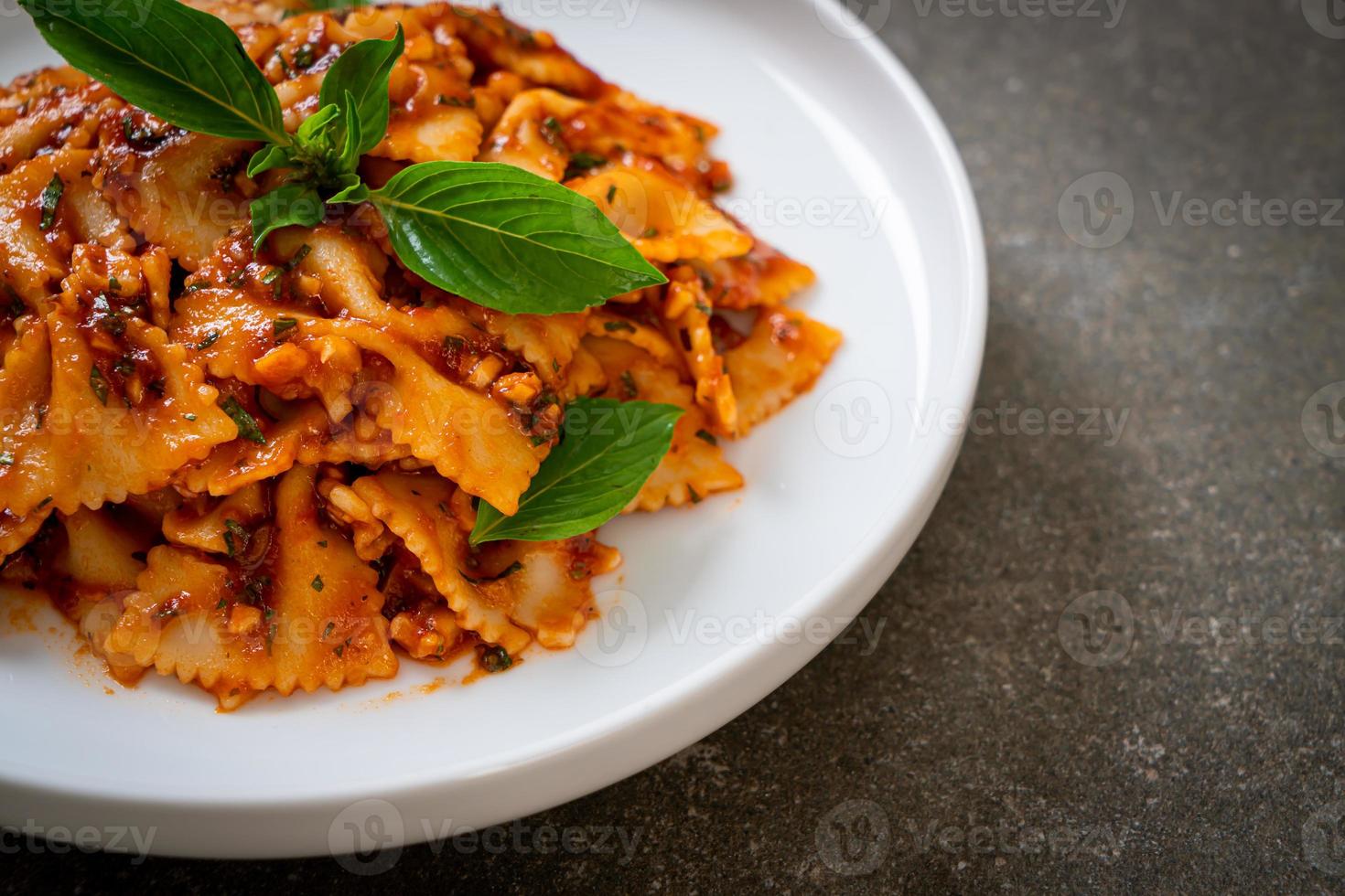 macarrão farfalle com manjericão e alho em molho de tomate - molho italiano foto