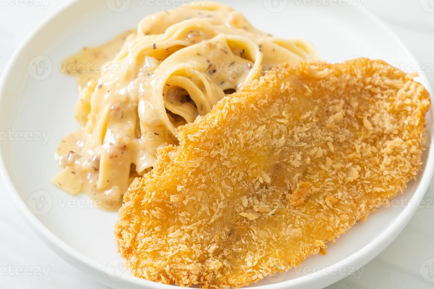 macarrão fettuccine caseiro com molho de creme branco com peixe frito foto