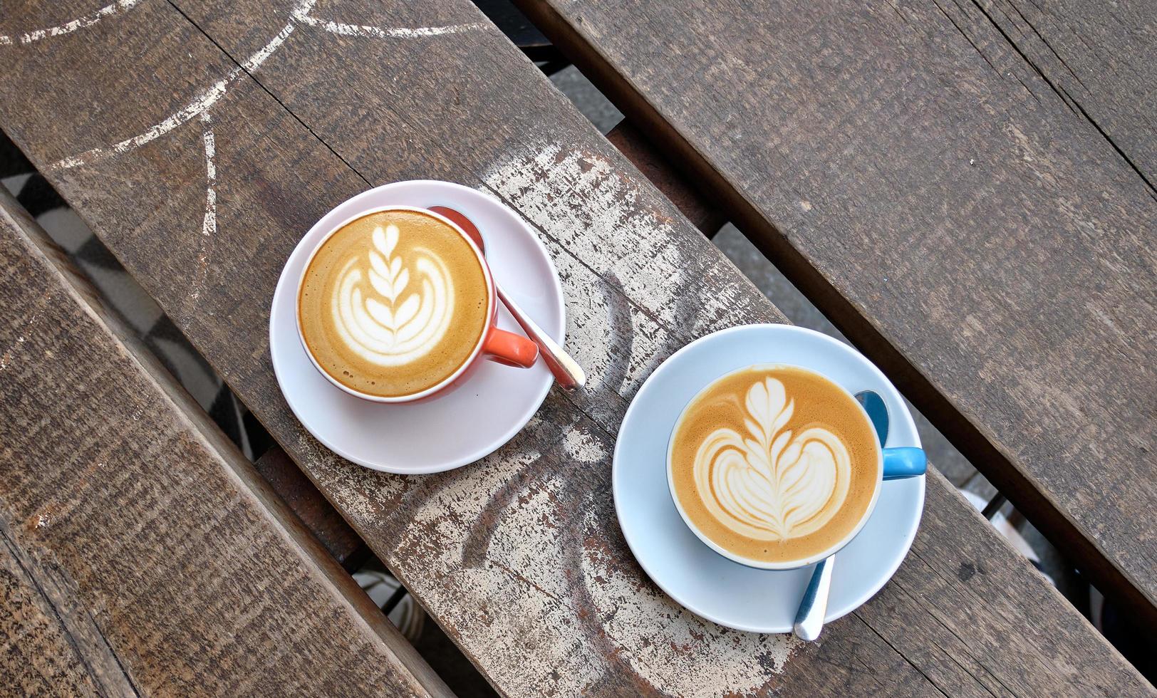 tomada de ângulo elevado de duas xícaras de café com leite em uma superfície de madeira foto