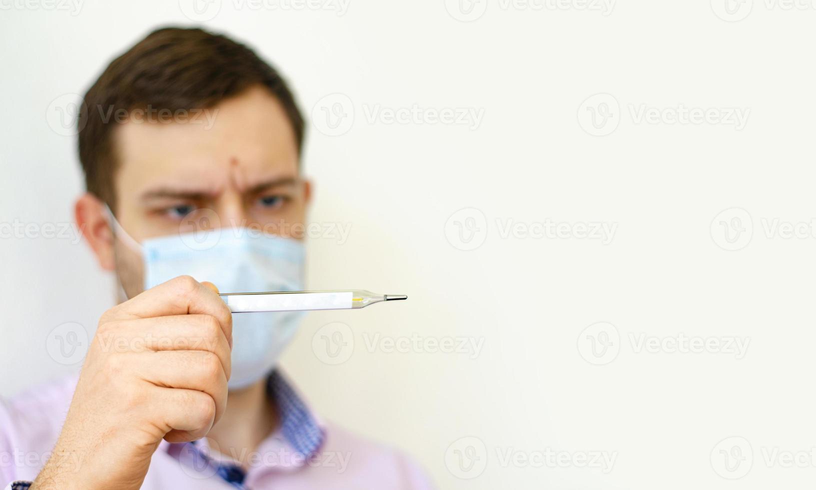 um homem de camisa mede a temperatura. Temperatura alta. foto