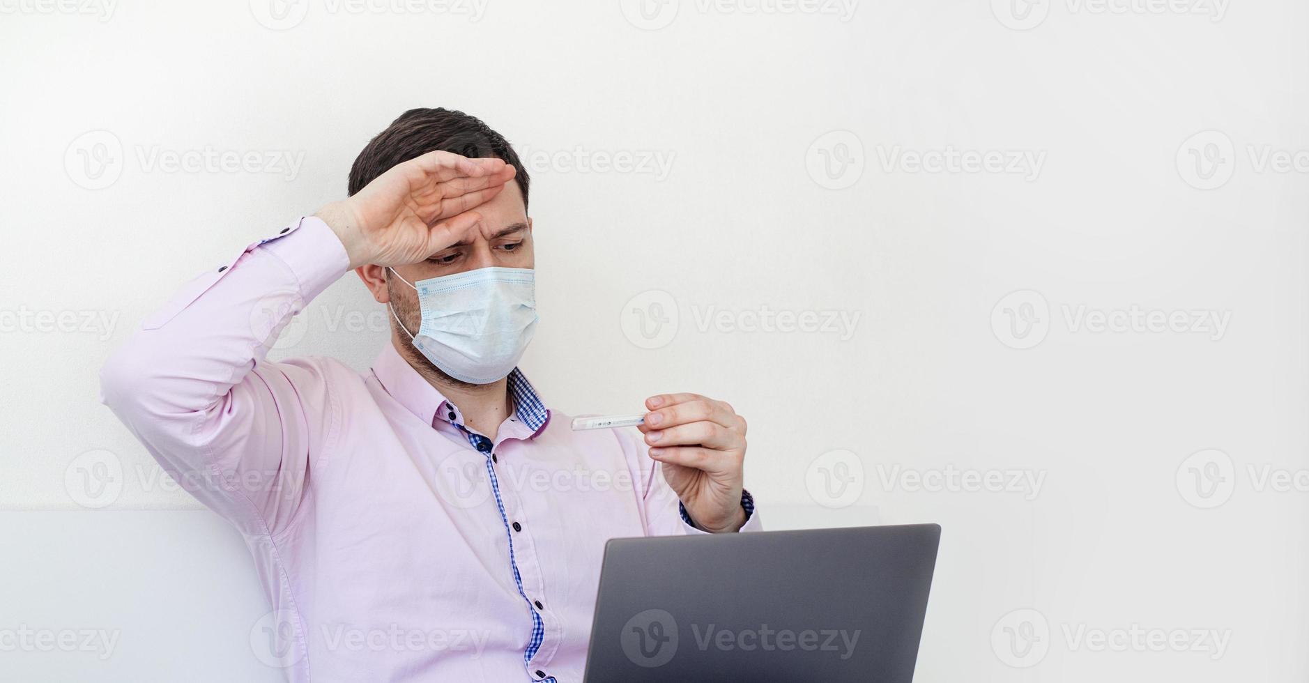 um homem de camisa mede a temperatura. Temperatura alta. foto