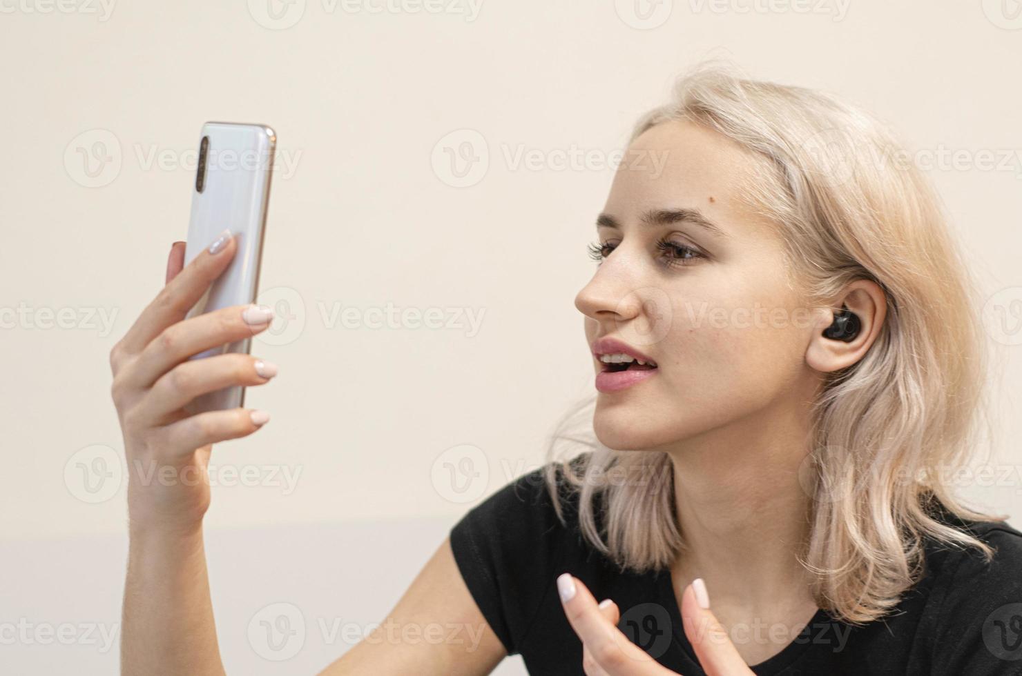 garota se comunica por videochamada. fone de ouvido sem fio. foto