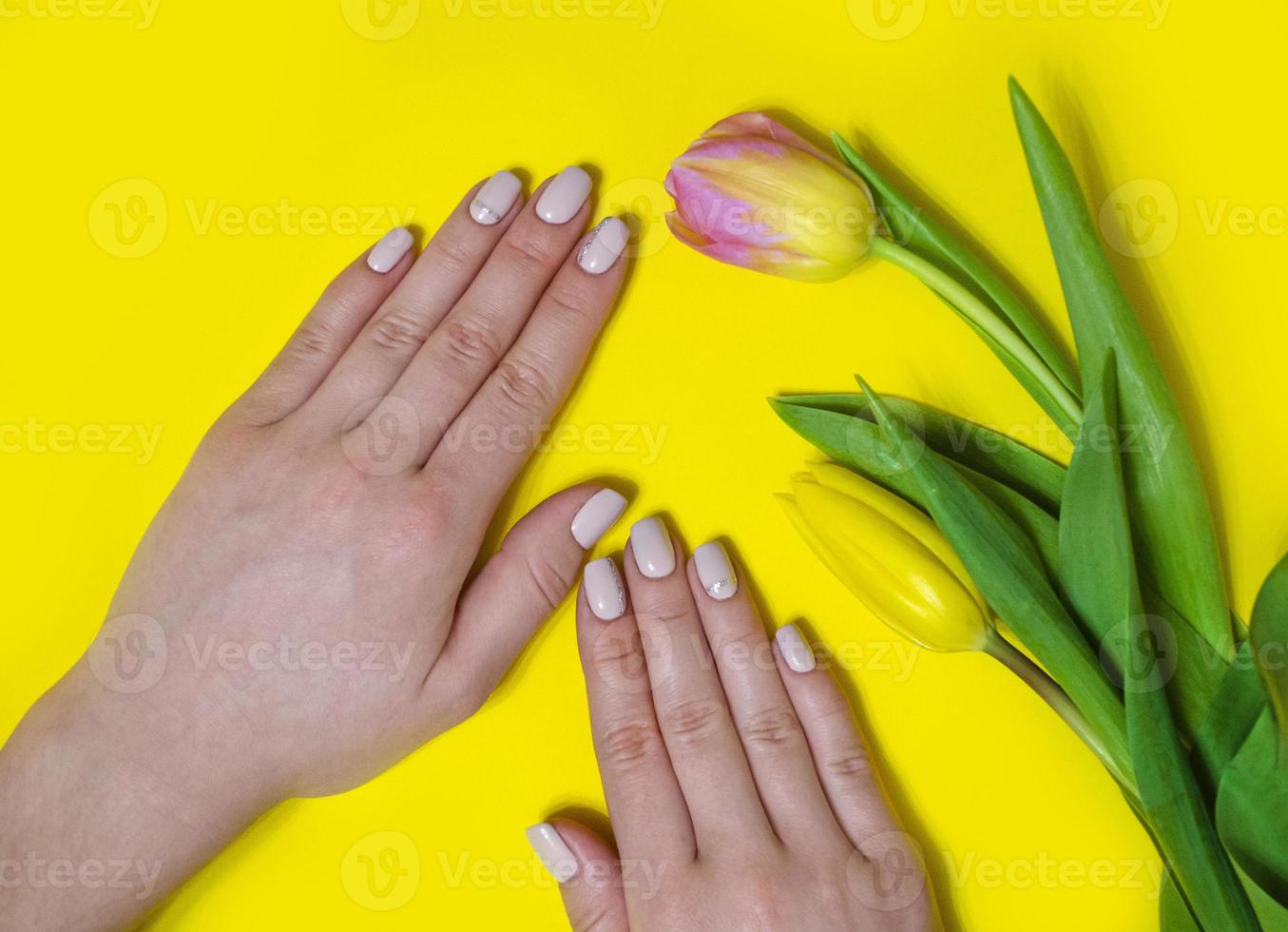 manicure feminina em um fundo brilhante. amarelo foto