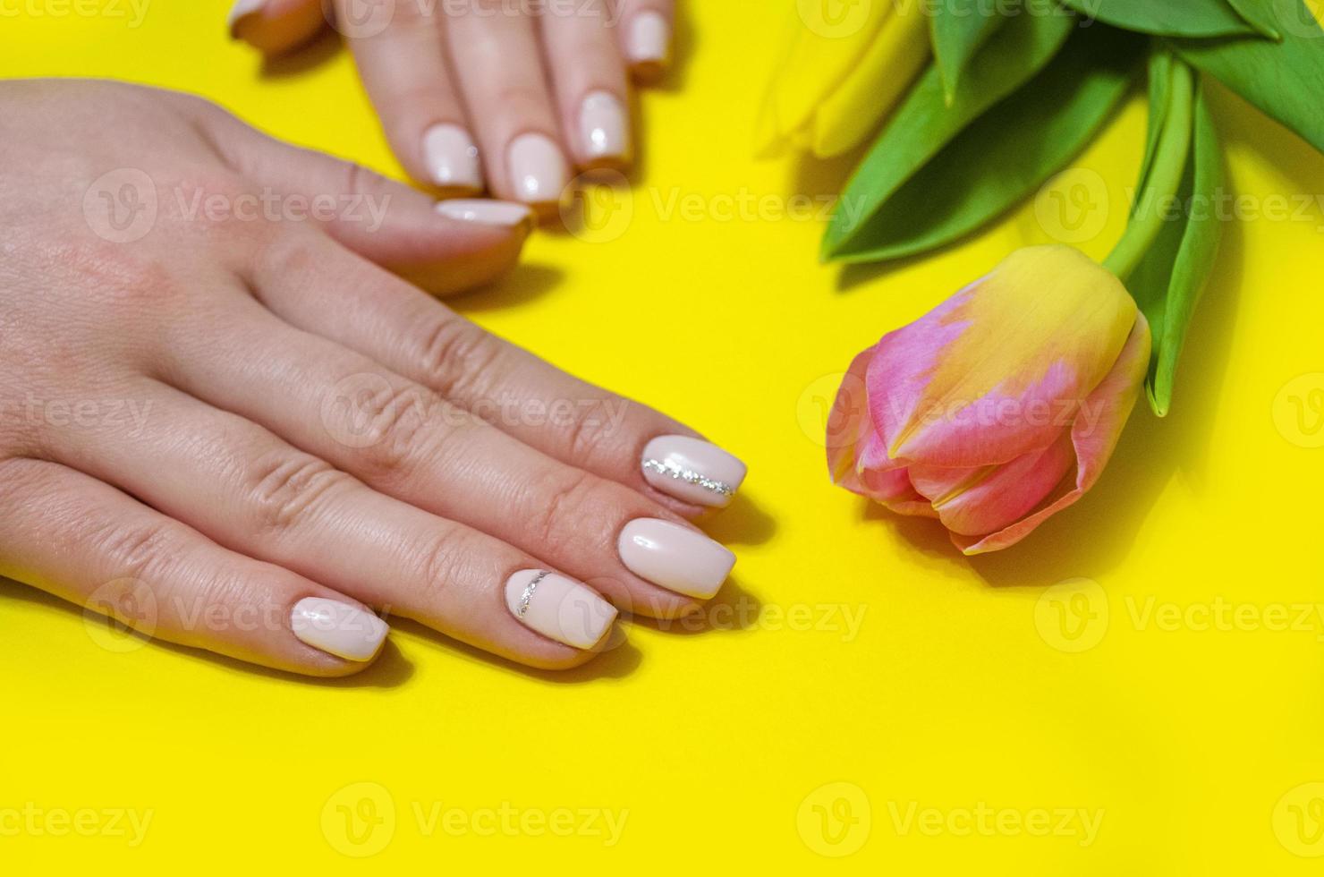 manicure feminina em um fundo brilhante. amarelo foto