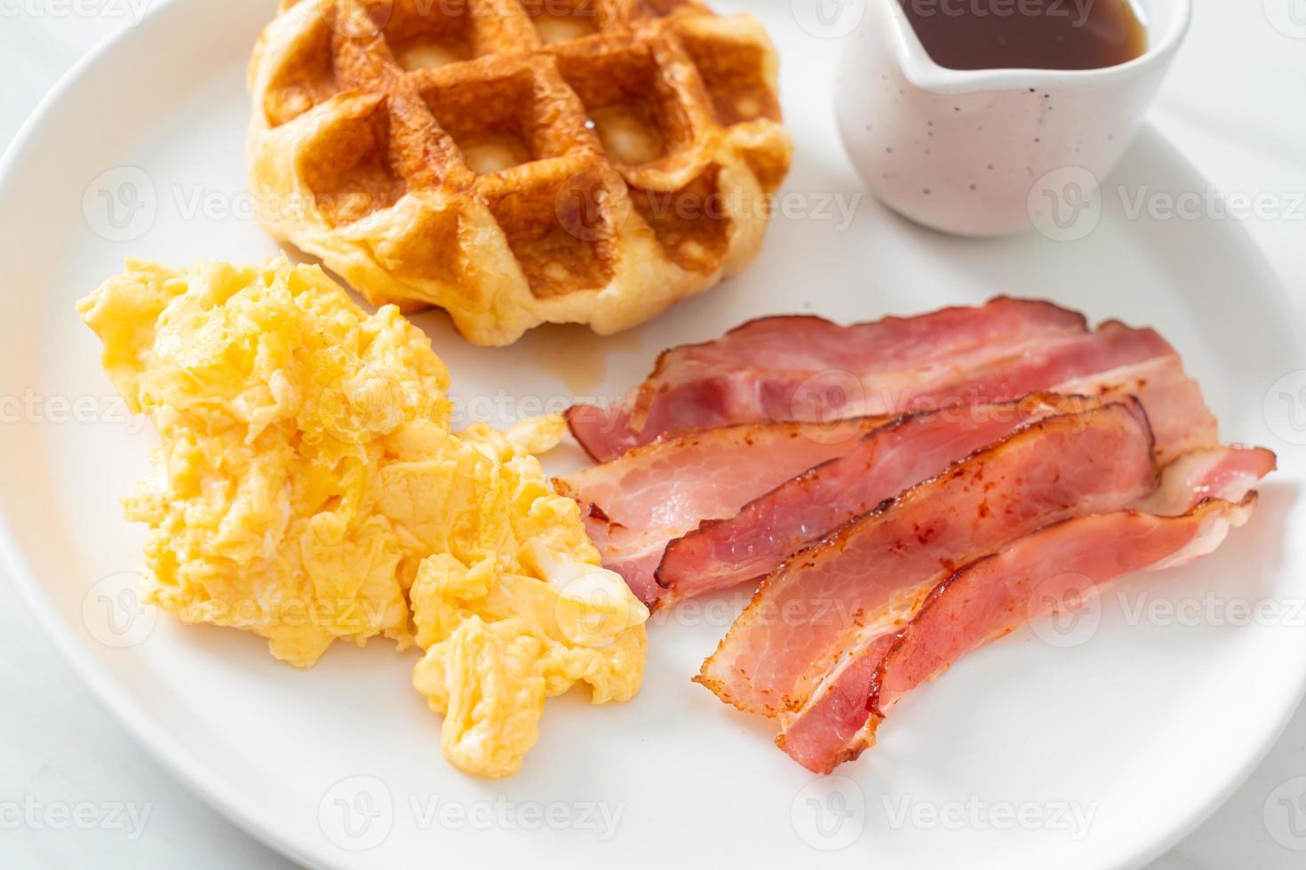 ovo mexido com bacon e waffle no café da manhã foto