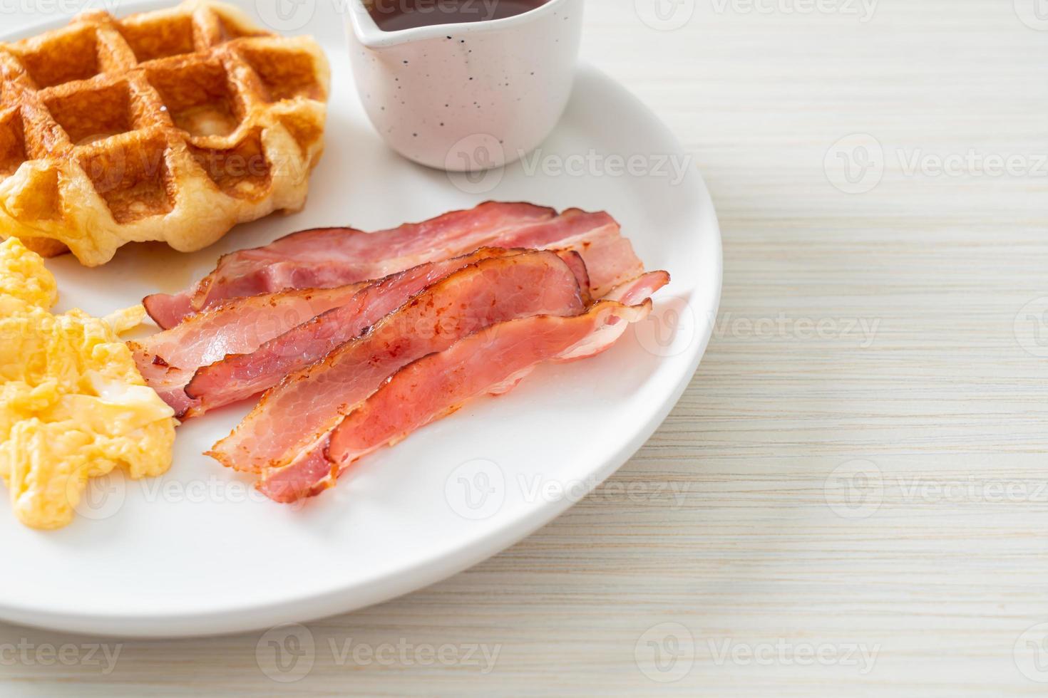 ovo mexido com bacon e waffle no café da manhã foto