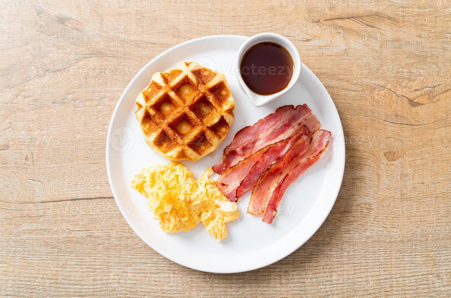 ovo mexido com bacon e waffle no café da manhã foto