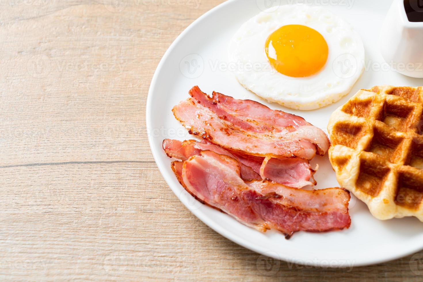 ovo frito com bacon e waffle no café da manhã foto