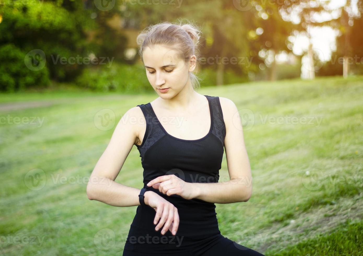 uma jovem usa um rastreador de fitness. relógio inteligente. foto