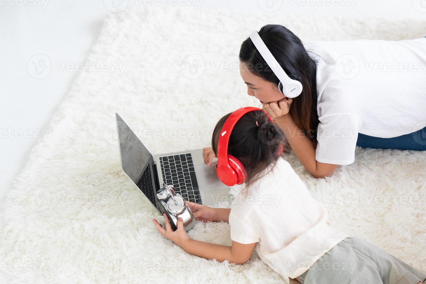 mãe asiática ensinando criança a estudar em um programa de computador em casa foto