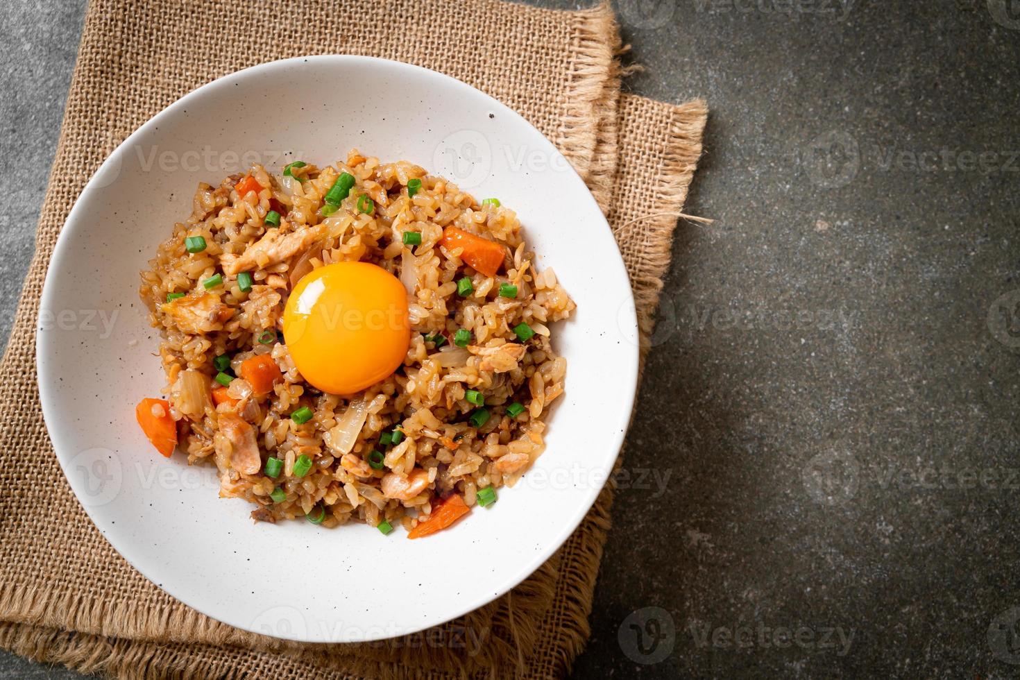 arroz frito de salmão com ovo em conserva por cima - comida asiática foto