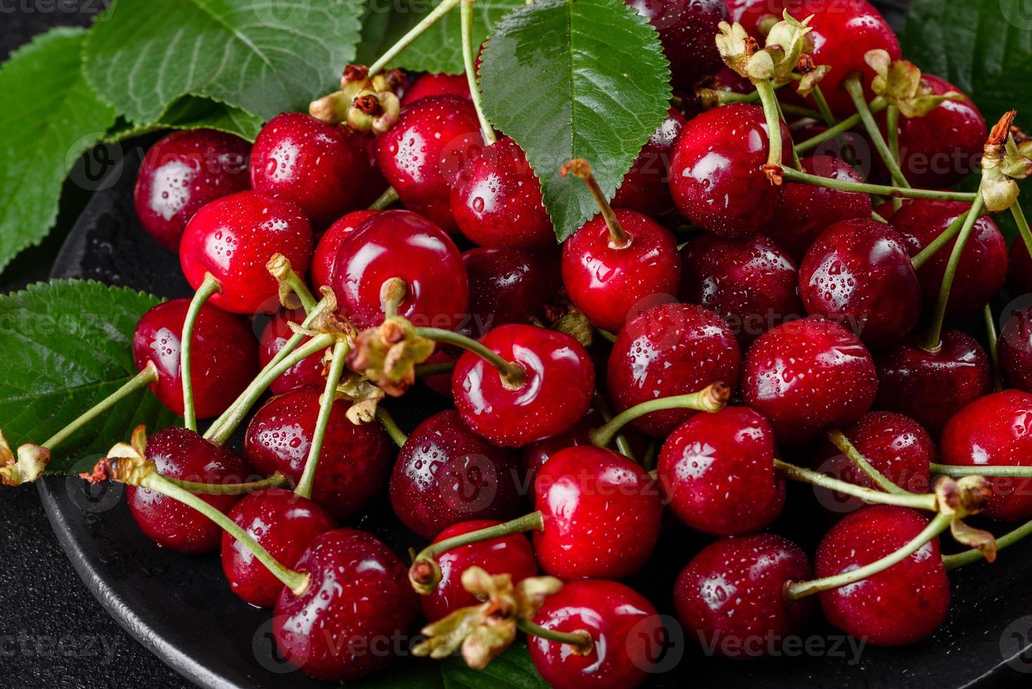 Frescas deliciosas bagas vermelhas brilhantes de cereja rasgadas no jardim de verão foto