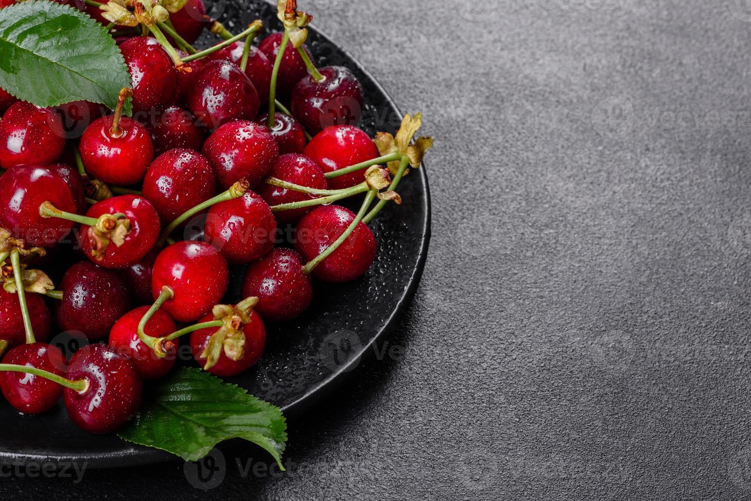 Frescas deliciosas bagas vermelhas brilhantes de cereja rasgadas no jardim de verão foto